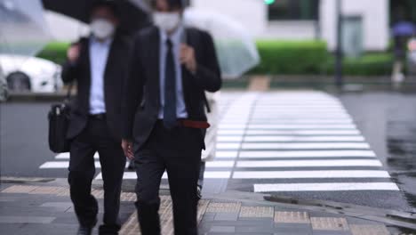 walking people on the street in marunouchi tokyo rainy day