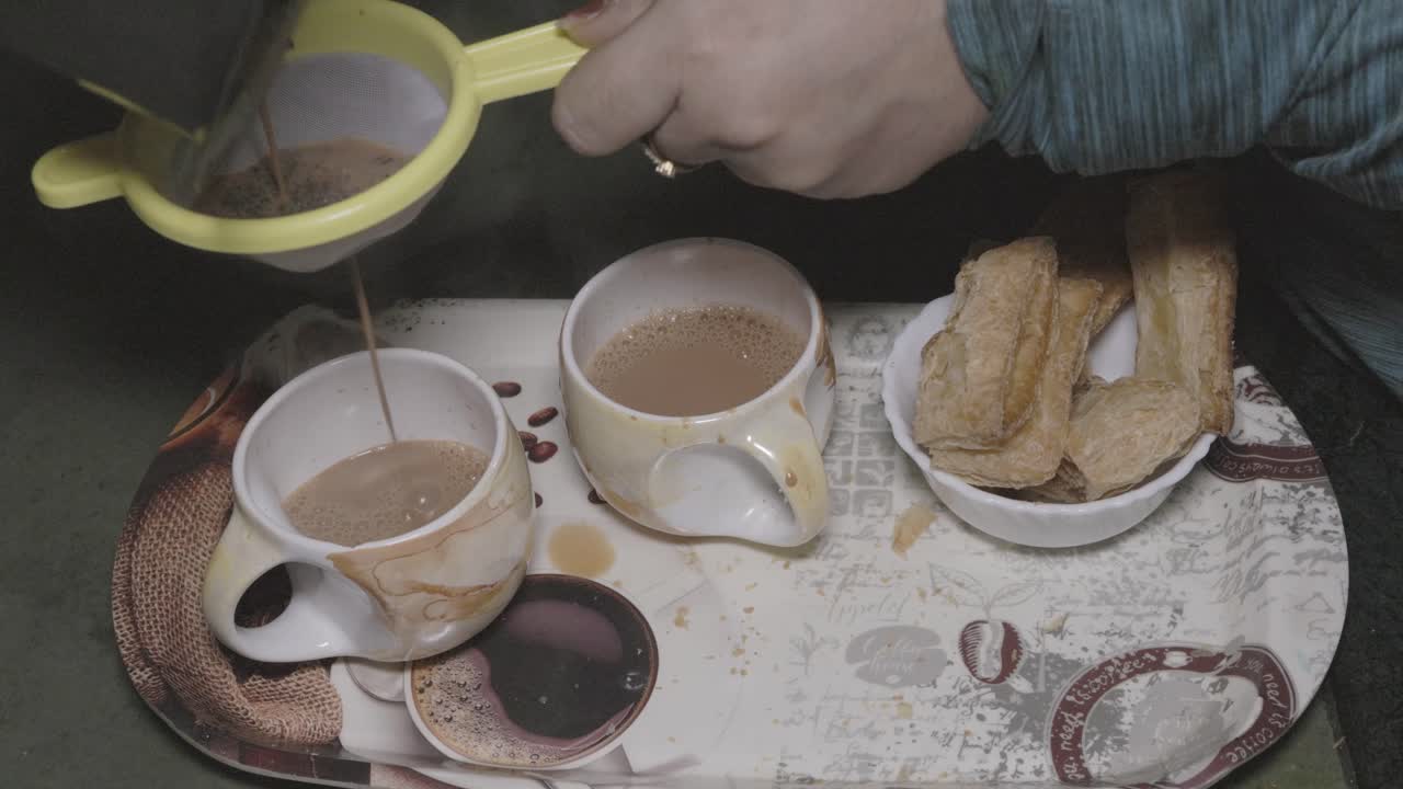 Girl Pouring Tea Through Strainer into Cup at Indoor
