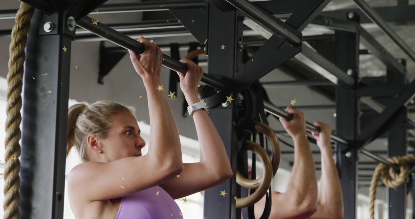 Training partners doing pullups in fitness gym, starting pull from hang, animated stars overlaying
