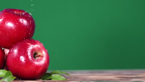 manzanas rojas frescas en la lluvia en una mesa de madera.