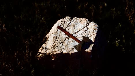 hacha de guerra para los vikingos en la roca al atardecer