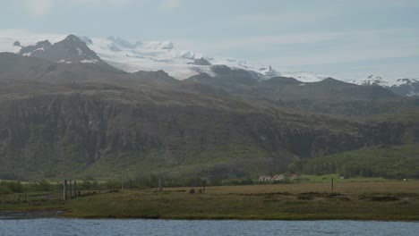 Ein-Ruhiger-See-In-Einem-Tal-In-Der-Nähe-Schneebedeckter-Berge