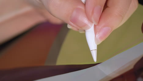 a tablet and pen being used to make a digital painting by an artist, macro