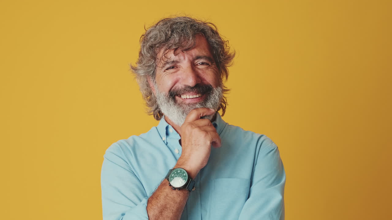 Mature Man Looks Thoughtful Then Smiles at Camera