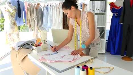 fashion designer sketching a design at table