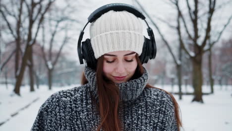 young woman enjoying music and serenity in a snowy winter landscape