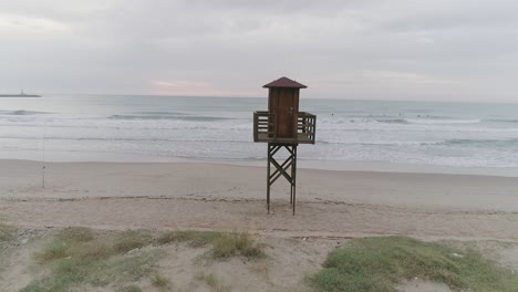 parallax effect footage of a lifeguard tower at the beach with surfers at the background.