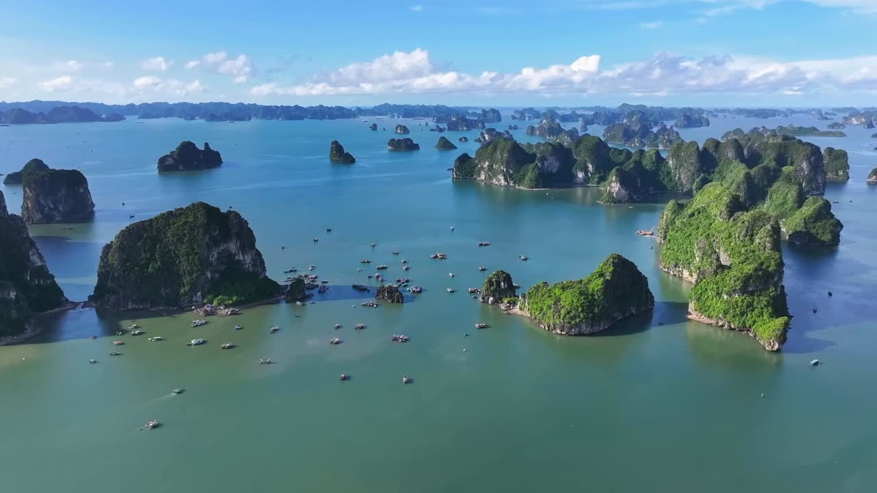 A breathtaking drone view captures Halong Bay’s emerald waters and towering limestone islands, with scattered boats adding life to this stunning natural seascape in northern Vietnam.