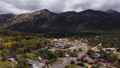 Colorado-mountain-town-during-the-fall-with-the-Rockies-in-the-background,-Aerial