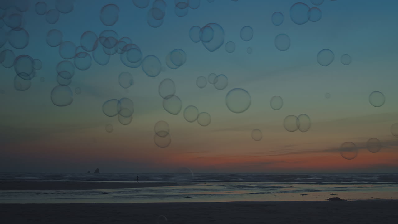 광활하고 텅 빈 해변에 해가 질 때 거품이 떠다닙니다.