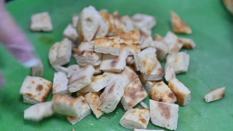 Chef-cutting-Turkish-bread-on-a-cutting-board,-Closeup-of-chef-slicing-bread-in-slow-motion