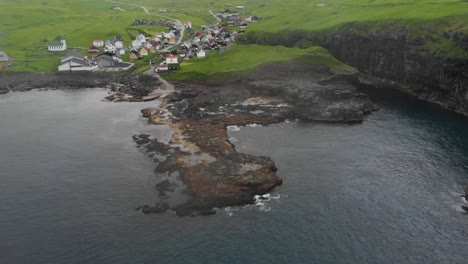 aerial of small town at sea at the faroe islands while raining