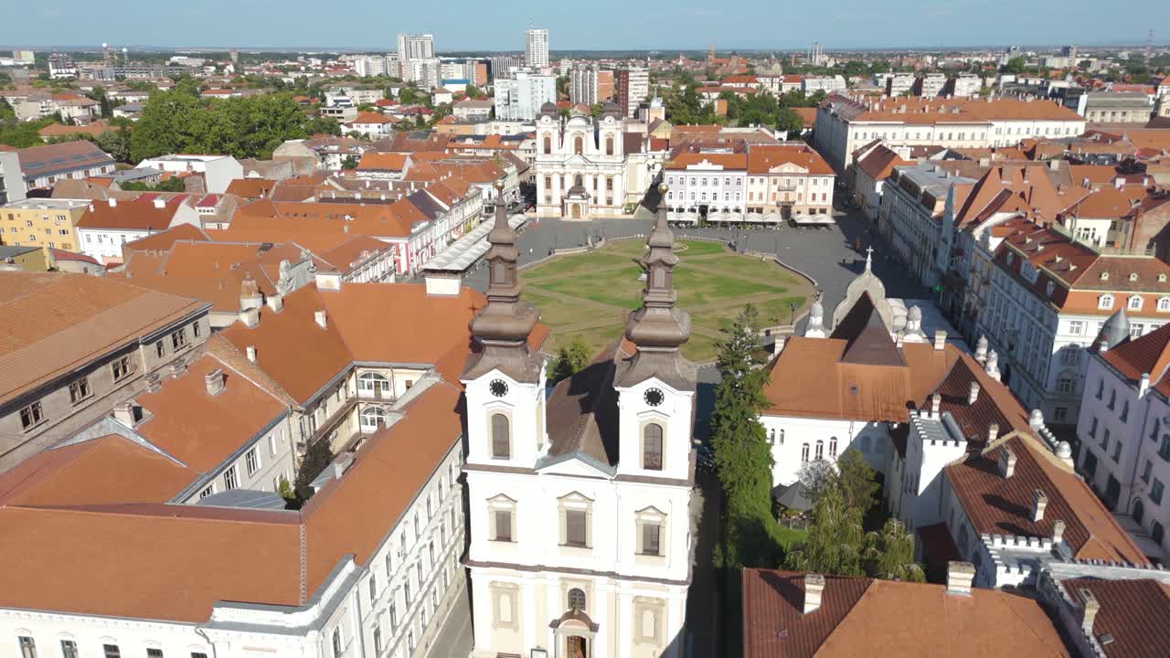 Aerial drone footage orbiting Union Square in Timisoara, Romania, highlighting the Serbian Orthodox Cathedral and the surrounding historic square