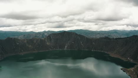 quilotoa crater in ecuador on a cloudy day - aerial pullback