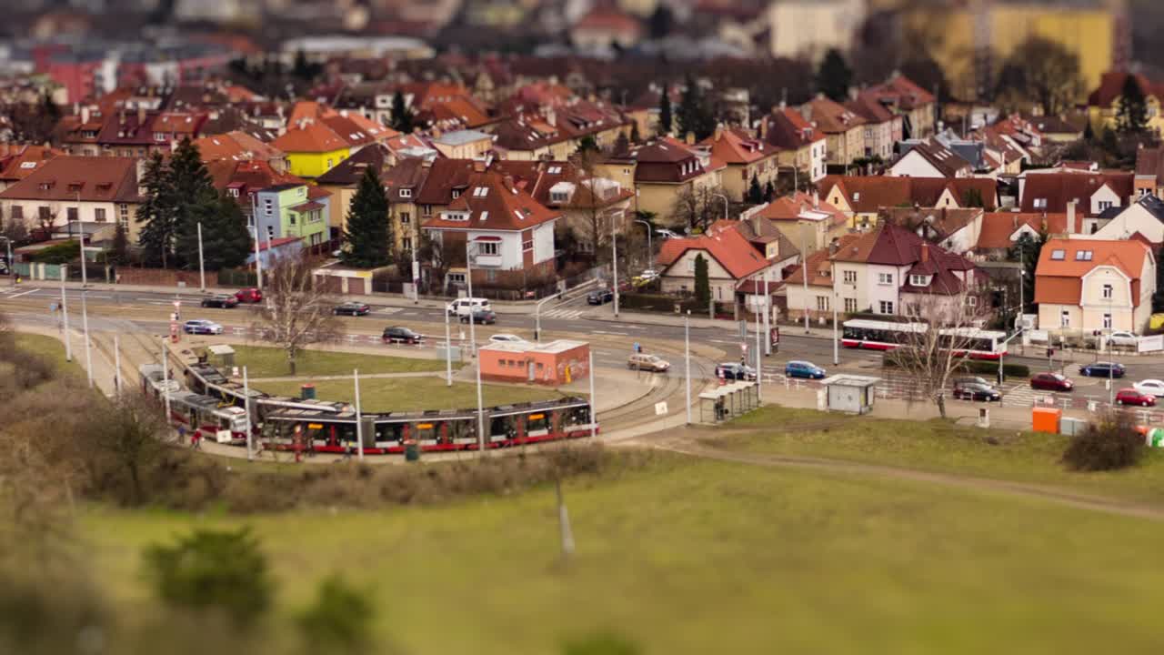 Aerial view of the Divoka Sarka tram stop and Ruzyne residential district in Prague. Usual traffic on the Evropska avenue, cars, busses and trams. People walking on the sidewalks. Hyperlapse video.