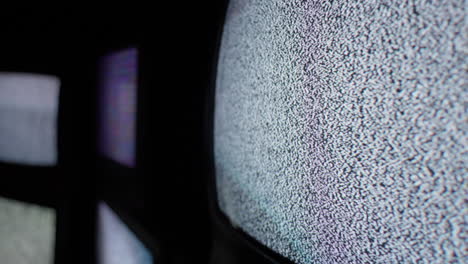 un ángulo cercano de las pantallas de televisión de cátodo que muestra sólo una señal de ruido blanco constante en una habitación oscura y aislada