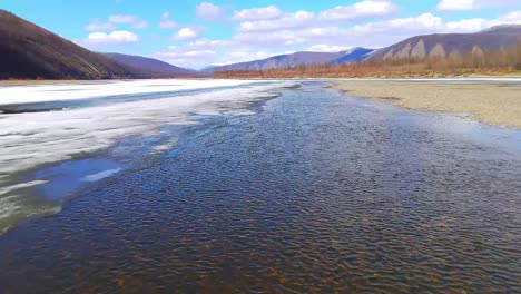 a large river thaws from ice in a sunny spring from a bird's eye view
