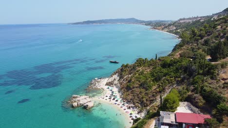 tourists enjoying small beach with clear blue water in summer - scenic beach at zakynthos, ionian islands of greece