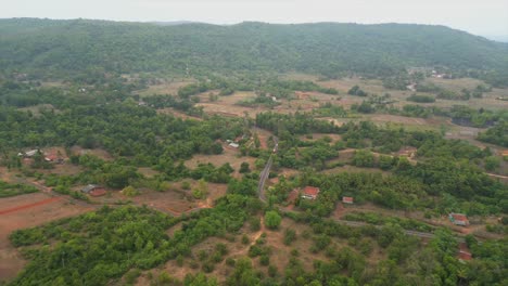 drone-following-bus-in-village-wide-view