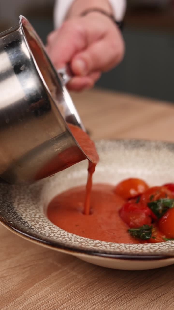 chef vertiendo sopa de tomate en un cuenco