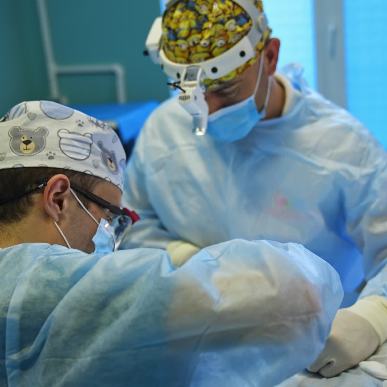 Co-working surgeons approached very close to a patient operating him. Doctors in funny caps use metal tools at work