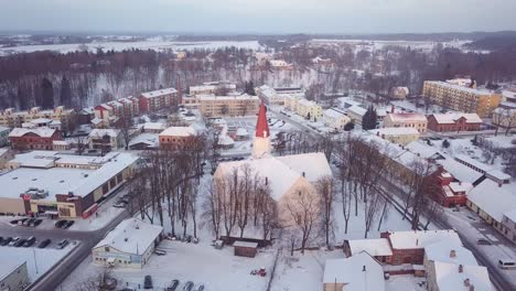 Aerial-rising-over-downtown-Smiltene-in-winter-with-Lutheran-church-highlighted