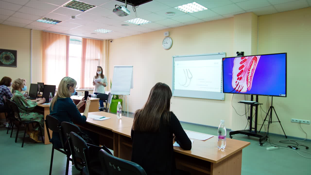 Students studying ophthalmology in medical university. Big screen showing the images of an eye.