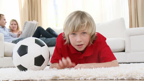 kid watching a football match in television on floor