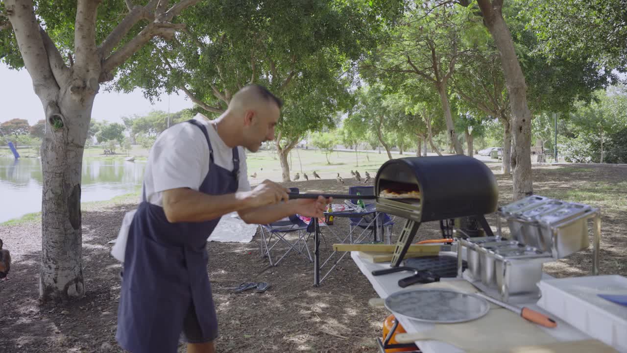 The outdoor pizza chef focuses on turning his margherita inside the Gozney oven, surrounded by nature, open space, and peaceful lakeside vibes