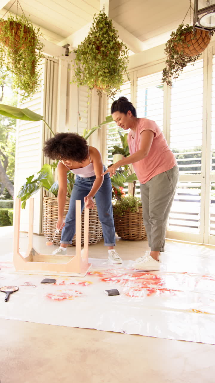 Vertical video: Painting furniture, two women working together on DIY home improvement project