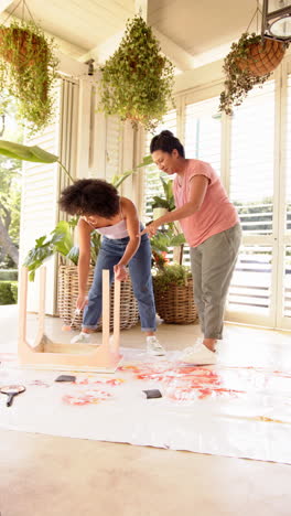 vertical video: painting furniture, two women working together on diy home improvement project