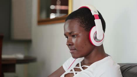 african lady working on laptop wearing earphones
