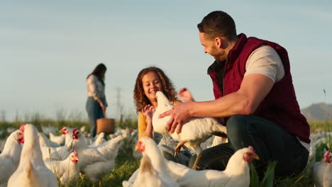 mother, father and child with a chicken on a farm