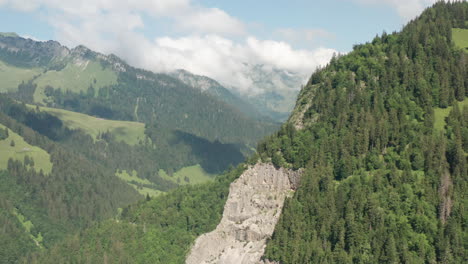 aerial of beautiful green mountainscape and revealing a stunning swiss valley