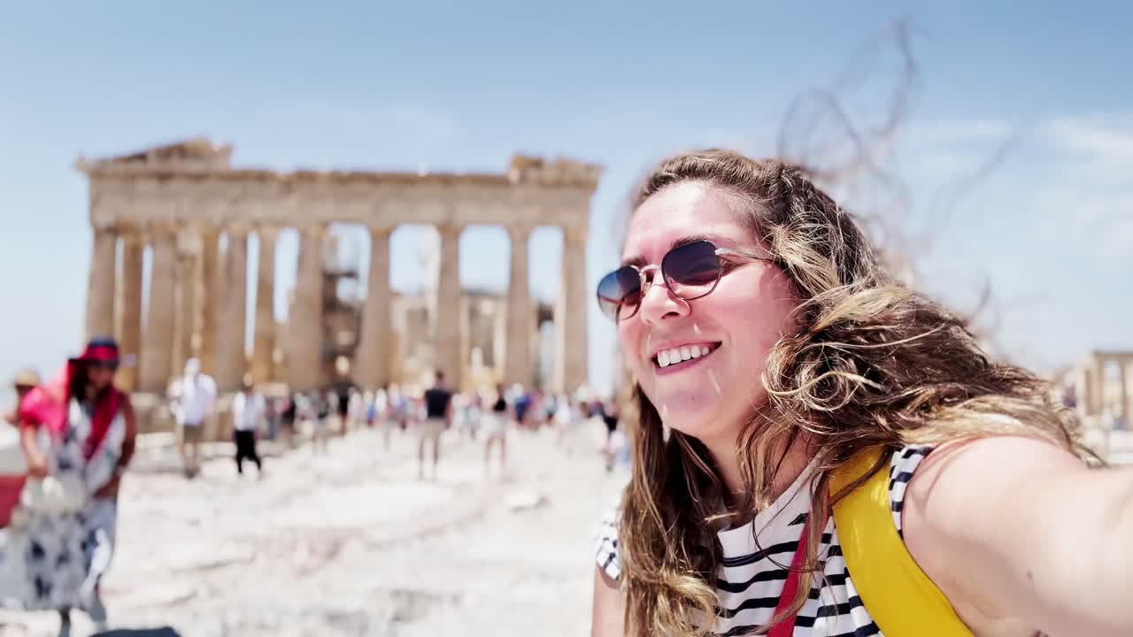 Cheerful Woman Waving for a Selfie at the Parthenon, Athens, Greece