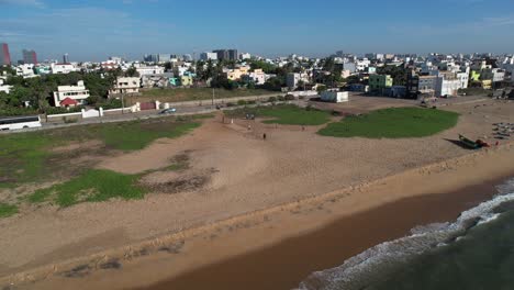 Dos-Pescadores-Están-Montando-Un-Pequeño-Bote-Cerca-De-La-Costa-Regresando-A-Sus-Casas-Y-Un-Grupo-De-Personas-Jugando-Al-Cricket.