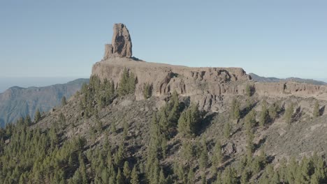 beautiful drone shot fly over the roque nublo with mountain panorama and forest, gran canaria