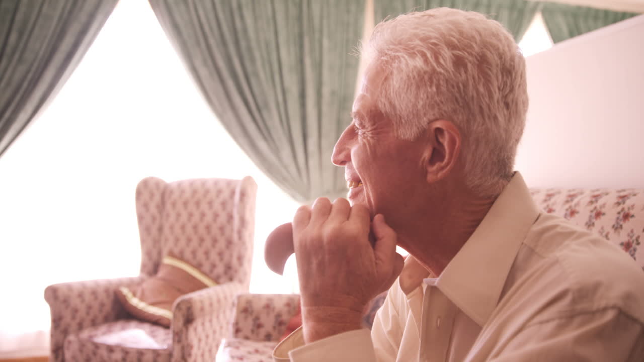 高齢の男性が座って笑顔を浮かべています
