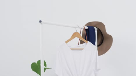 video of white t shirt on hanger with hat and copy space on white background