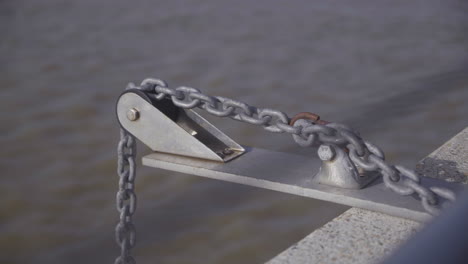 cadena en un sistema de poleas colgando sobre el mar en cámara lenta