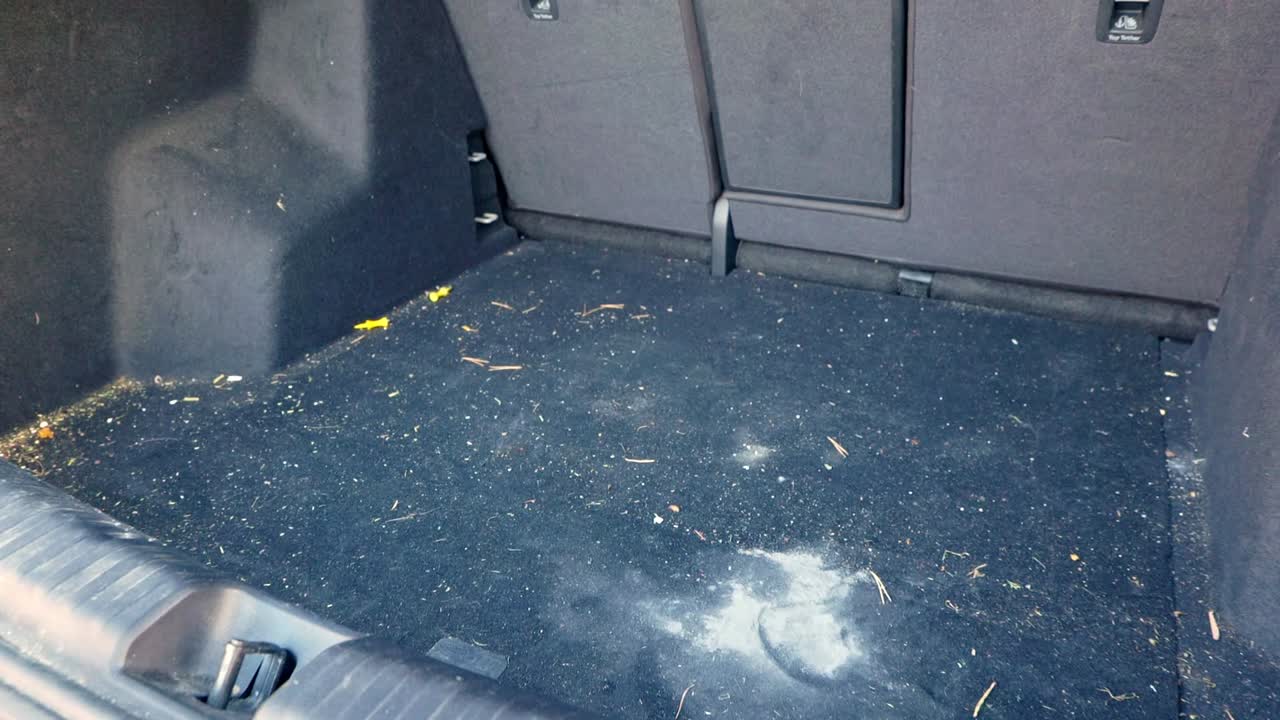 Extremely dirty SUV trunk with hay, straw and plaster in the carpet - dolly out - close up to wide