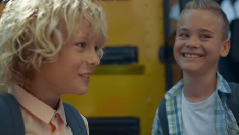 three teen boys standing at bus door laughing close up. smiling pupils chatting.