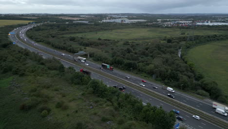 Erstellen-Einer-Luftdrohnenaufnahme-Des-Autobahnverkehrs-Der-M1-Im-Morgengrauen-An-Einem-Bewölkten-Tag-Außerhalb-Von-Leeds,-Großbritannien,-Mit-Fahrzeuglichtern