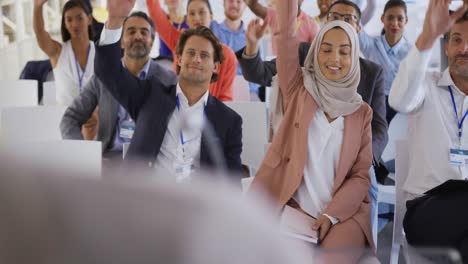 audience at a business presentation raising their hands to ask questions