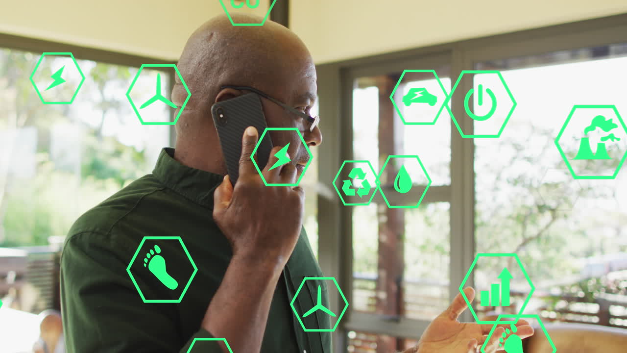 animación de iconos ecológicos sobre empresario afroamericano en teléfono inteligente en la oficina