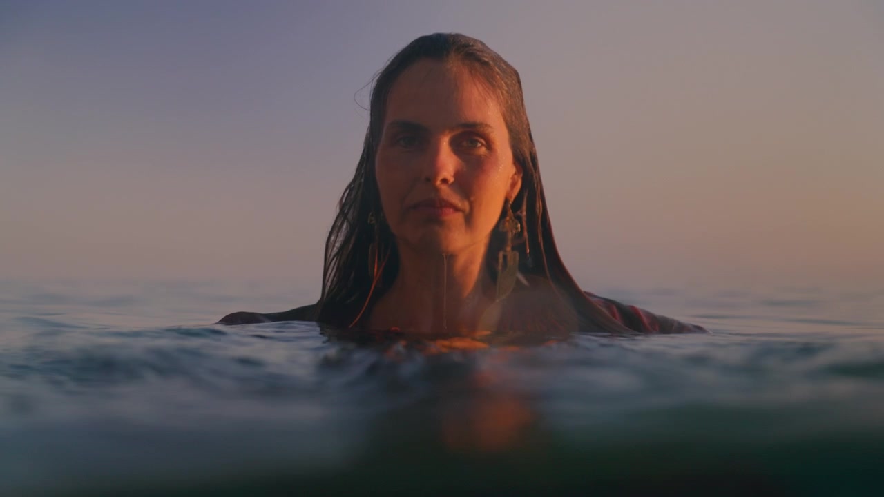 Un ritratto calmo mostra una donna che galleggia sulla superficie dell'acqua da un'angolazione diversa.