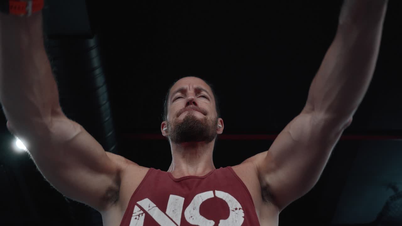 Focused man lifting weights in a gym, wearing a "No Pain" tank top. Concept of strength, fitness, motivation, and dedication to bodybuilding and personal training