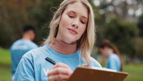 una joven voluntaria escribe en un clipboard en un parque