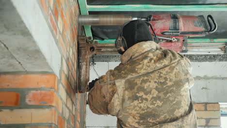 worker drills a wall with a powerful power tool makes holes for laying communications