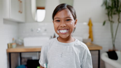 una niña feliz, cepillándose los dientes